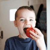 Criança comendo uma maça